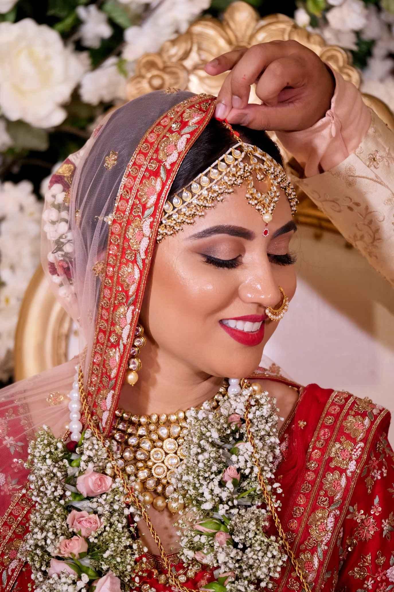 Groom putting Sindur on bride's forehead.